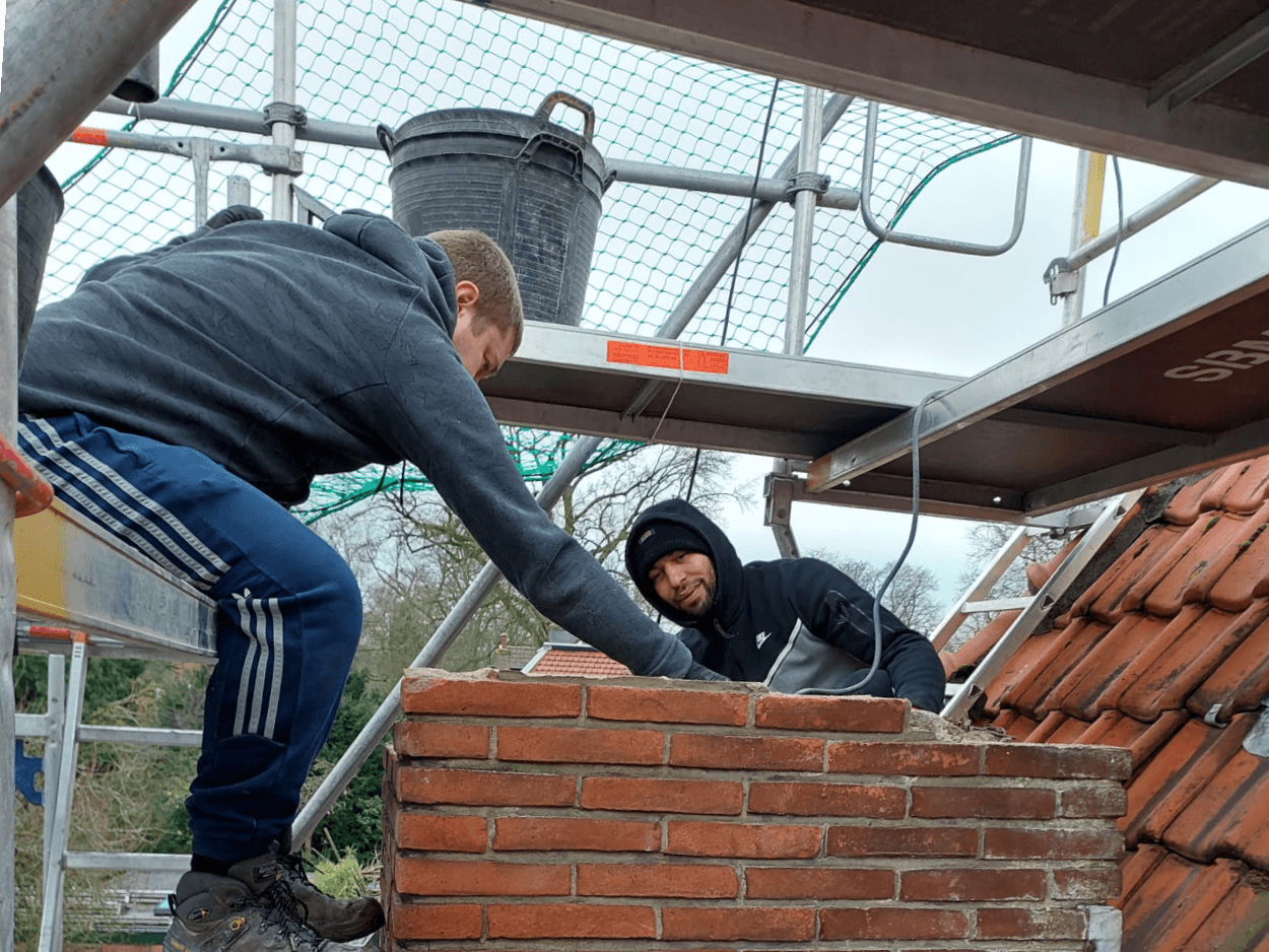 Close-up van het zorgvuldig losbikken van het metselwerk en loodslabben in Haarlem
