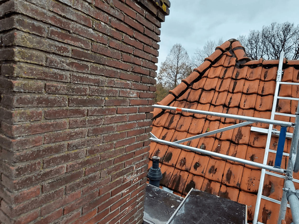 Bestaande gemetselde schoorsteen op het pannendak in Haarlem vóór de sloopwerkzaamheden